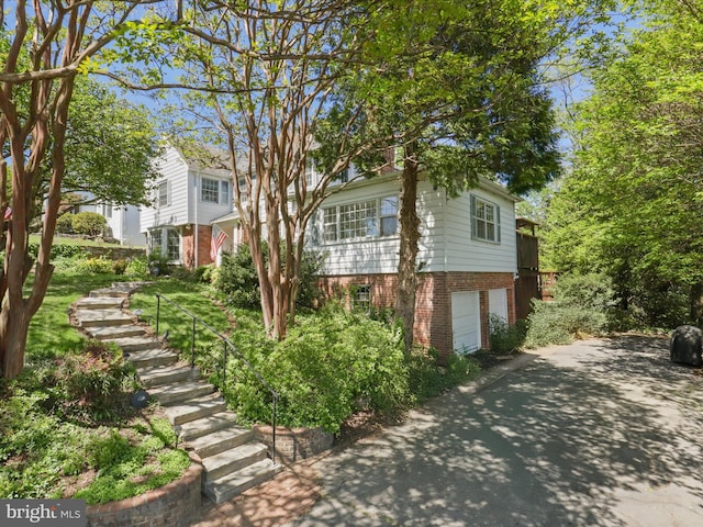 exterior space featuring brick siding, driveway, and a garage