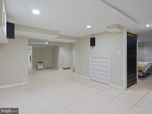 finished basement featuring light tile patterned floors, baseboards, and recessed lighting