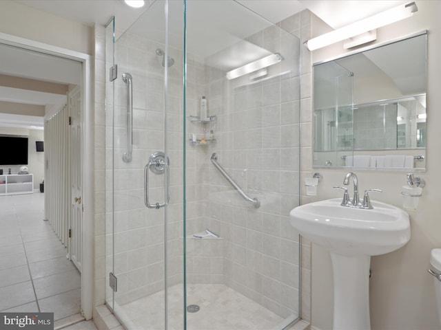 bathroom featuring tile patterned floors, toilet, and a shower stall