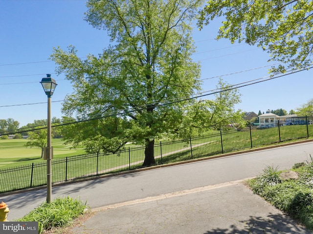view of street featuring golf course view and street lights