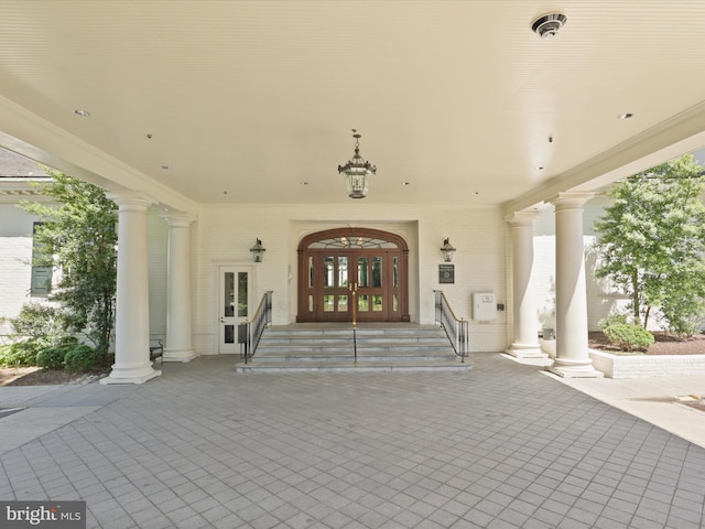 view of exterior entry featuring french doors and brick siding