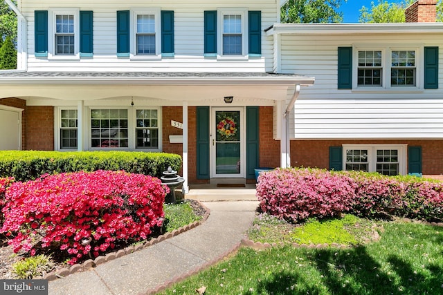5311 Crestedge Ln, Rockville, MD 20853 - view of exterior entry with brick siding, covered porch, and a chimney