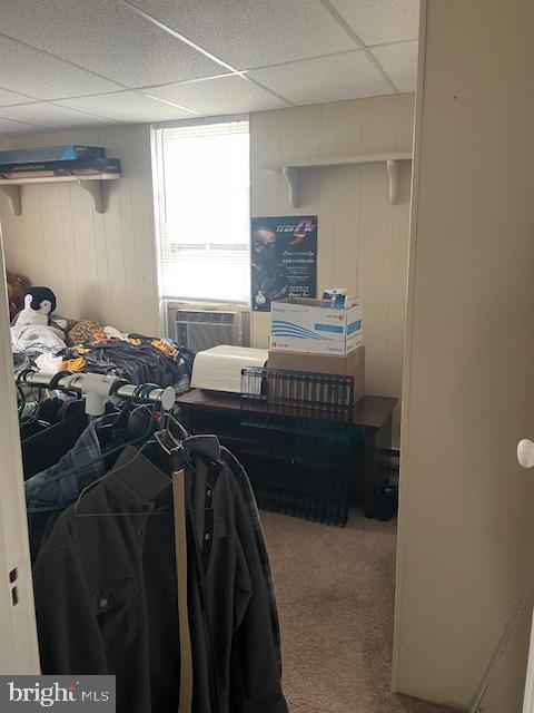bedroom featuring cooling unit, carpet, and a paneled ceiling