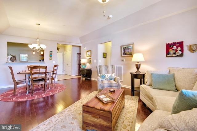 living area with baseboards, visible vents, wood-type flooring, and a chandelier