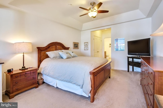 bedroom with light colored carpet, baseboards, ceiling fan, and ensuite bath