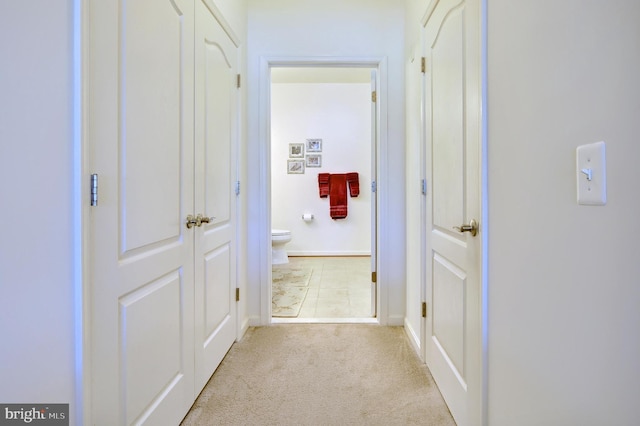 hallway featuring baseboards and carpet flooring
