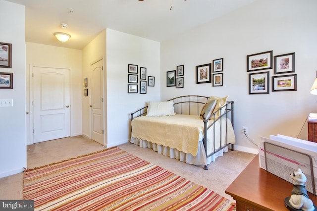 bedroom with baseboards and light colored carpet