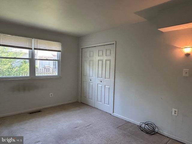 unfurnished bedroom with carpet floors, baseboards, and a closet