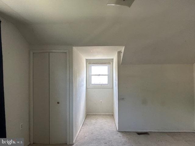 bonus room with light colored carpet and lofted ceiling