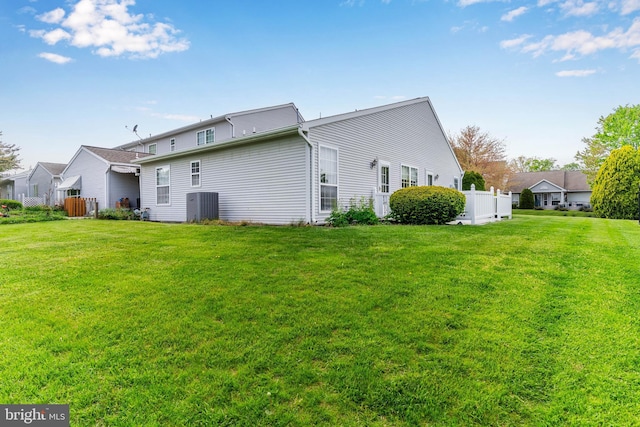 back of house with a lawn, central AC, and fence