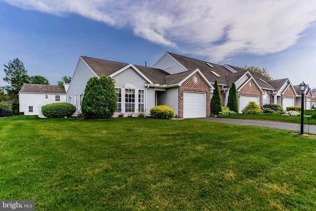view of front facade featuring brick siding, a garage, a front lawn, and aphalt driveway