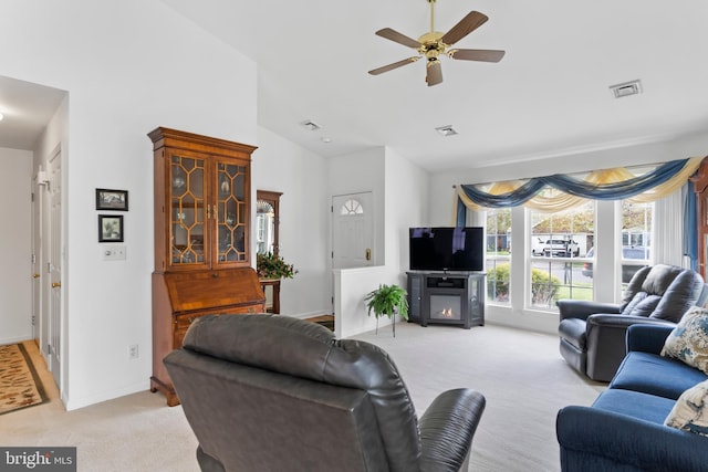 living area with baseboards, visible vents, a ceiling fan, and light colored carpet