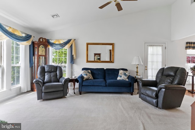 living room featuring visible vents, carpet, a healthy amount of sunlight, and lofted ceiling