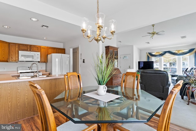 dining space featuring visible vents, recessed lighting, light wood-style floors, and ceiling fan with notable chandelier
