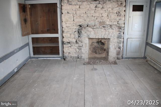 9635 Upper Strasburg Rd, Upperstrasburg, PA 17265 - unfurnished living room featuring wood finished floors and a fireplace