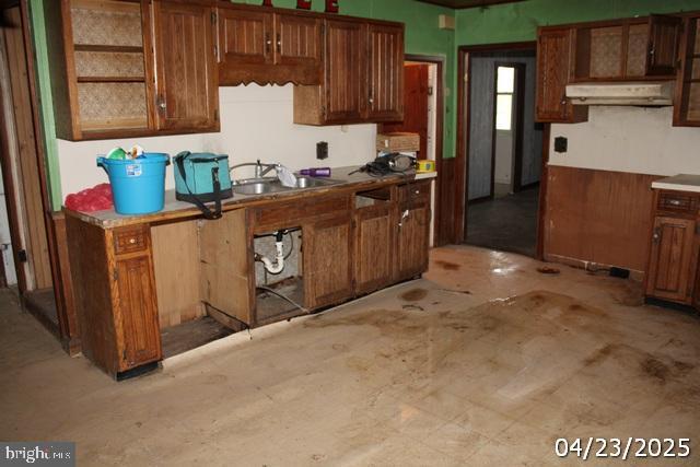 9635 Upper Strasburg Rd, Upperstrasburg, PA 17265 - kitchen featuring brown cabinets, under cabinet range hood, and a sink