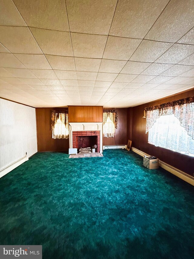 377 Main St, Cedarville, NJ 08311 - interior space with wood walls, carpet, baseboard heating, and a brick fireplace