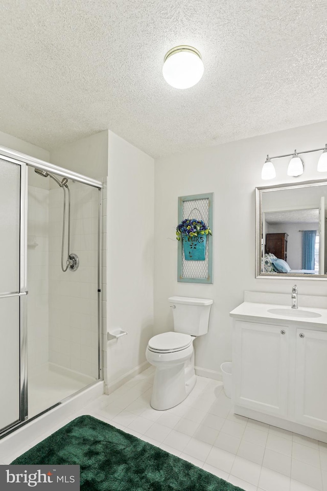 bathroom featuring a textured ceiling, toilet, and a shower stall