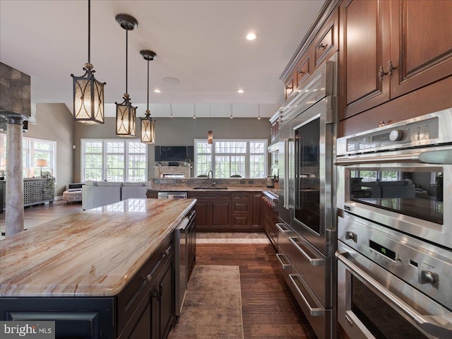 kitchen with open floor plan, butcher block countertops, a healthy amount of sunlight, and a sink