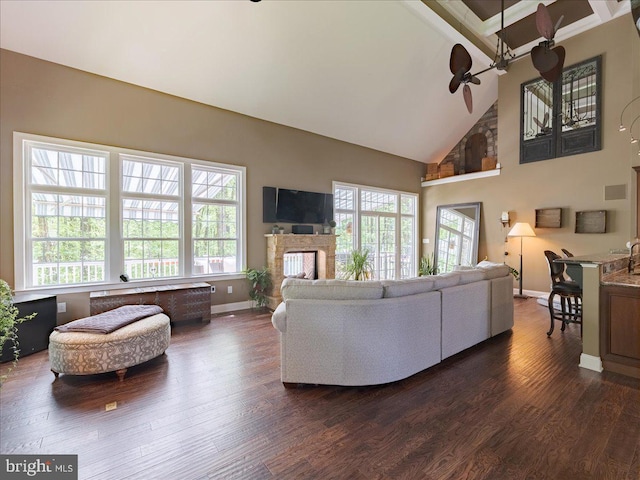living area with a ceiling fan, baseboards, a wealth of natural light, and high vaulted ceiling