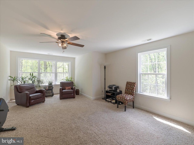 living area with baseboards, carpet, a ceiling fan, and visible vents