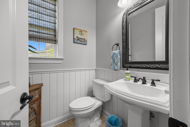 bathroom with a wainscoted wall and toilet