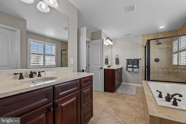 bathroom featuring a sink, plenty of natural light, a shower stall, and visible vents