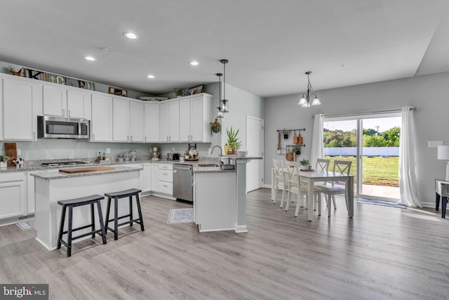 9937 Sodus Ct, Faulkner, MD 20632 - kitchen with a peninsula, a breakfast bar area, a sink, stainless steel appliances, and a chandelier