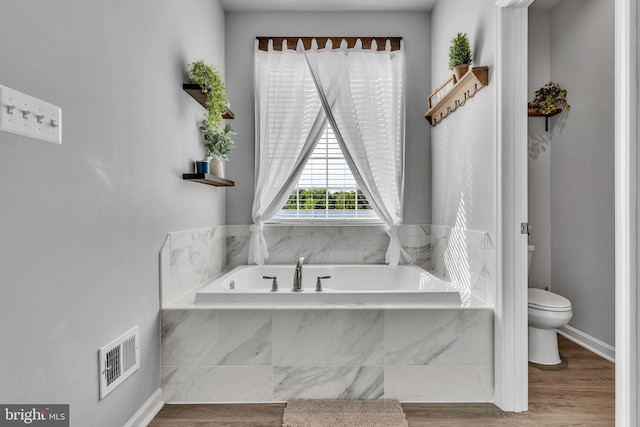 9937 Sodus Ct, Faulkner, MD 20632 - full bathroom with a garden tub, toilet, visible vents, and wood finished floors