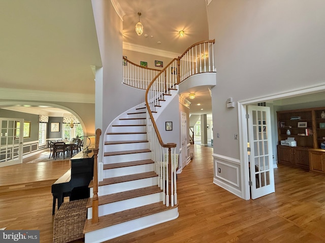 14309 Cervantes Ave, Darnestown, MD 20874 - stairs featuring crown molding, arched walkways, wood finished floors, and a towering ceiling