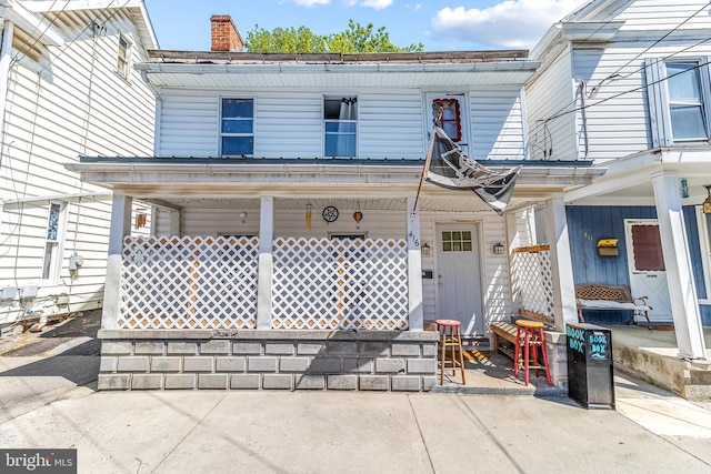 exterior space with covered porch and a chimney