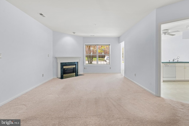unfurnished living room featuring light colored carpet, baseboards, visible vents, and a fireplace