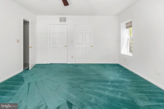 unfurnished bedroom with carpet floors, baseboards, a ceiling fan, and visible vents