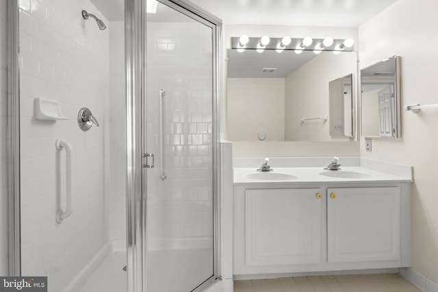 full bathroom with double vanity, a sink, visible vents, and a shower stall