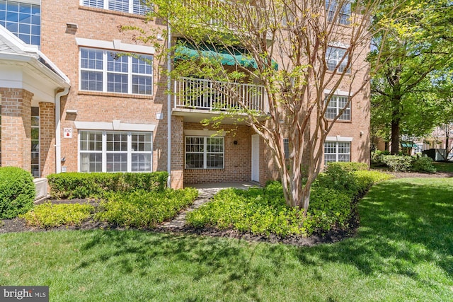 exterior space featuring a yard and brick siding