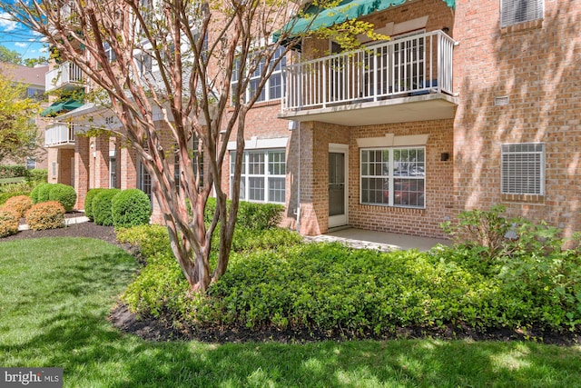 doorway to property featuring brick siding and a balcony