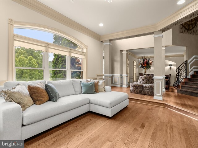 6 Jarretts Ct, Reisterstown, MD 21136 - living room featuring ornate columns, crown molding, light wood finished floors, a decorative wall, and stairway