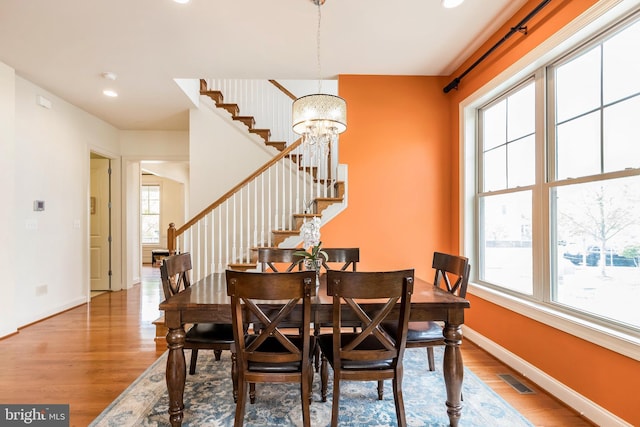 dining room with baseboards, stairway, plenty of natural light, and wood finished floors