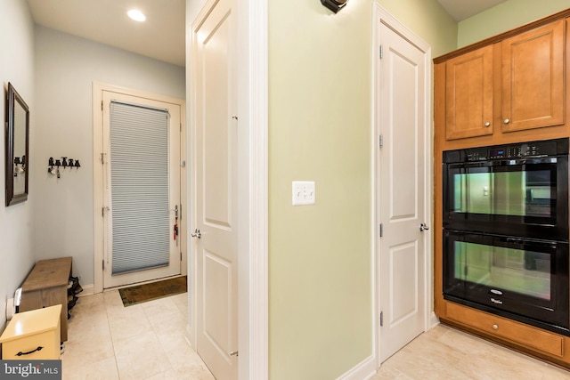 doorway with baseboards, recessed lighting, and light tile patterned flooring