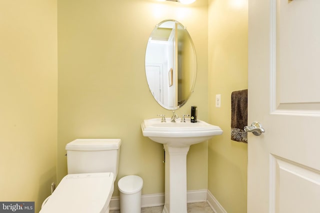 half bathroom with toilet and baseboards