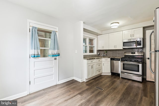 2026 S Oakland St S, Arlington, VA 22204 - kitchen with visible vents, white cabinets, dark wood-type flooring, stainless steel appliances, and tasteful backsplash