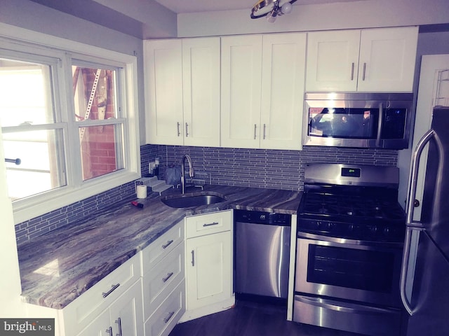 2026 S Oakland St S, Arlington, VA 22204 - kitchen with a sink, dark stone counters, white cabinetry, decorative backsplash, and appliances with stainless steel finishes