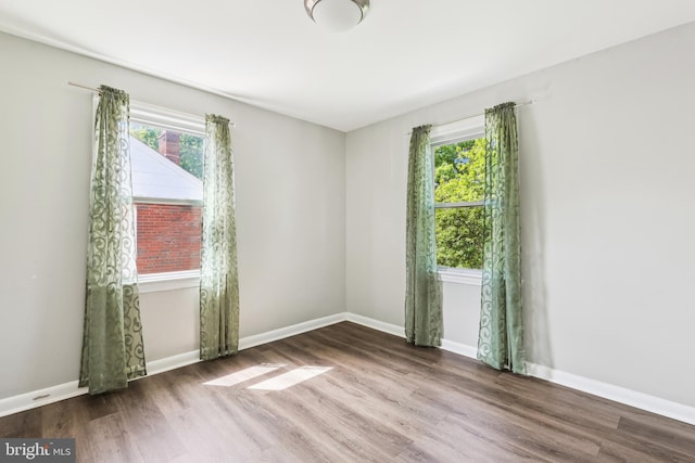 2026 S Oakland St S, Arlington, VA 22204 - empty room with a wealth of natural light, baseboards, and wood finished floors