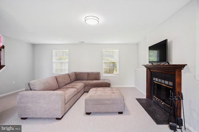 living room featuring plenty of natural light, a fireplace with flush hearth, and carpet