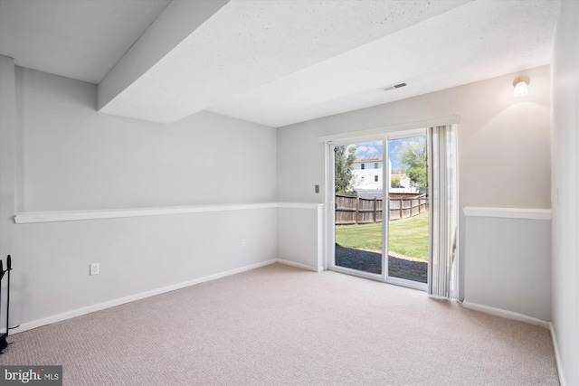 carpeted empty room featuring baseboards and visible vents