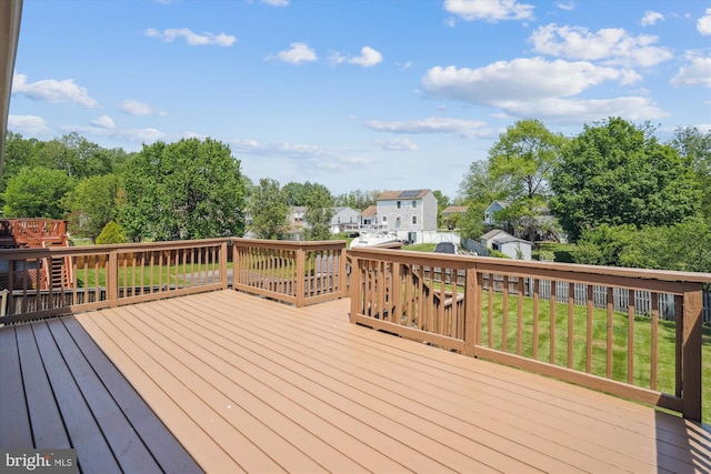 wooden deck featuring a lawn and a residential view