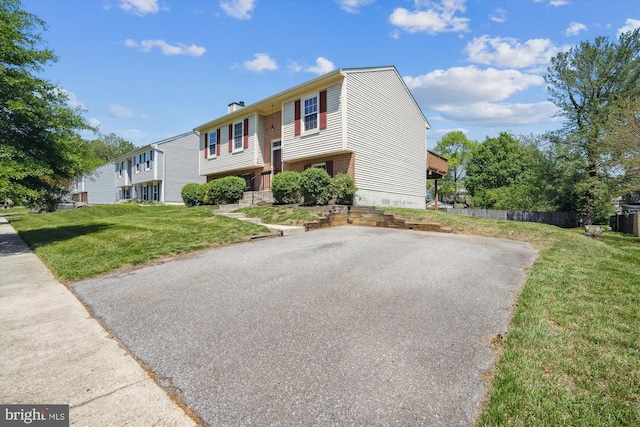 raised ranch with brick siding and a front lawn