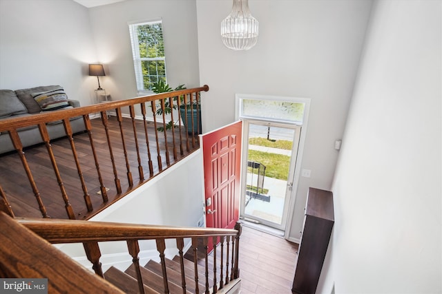 foyer entrance featuring baseboards, an inviting chandelier, and wood finished floors