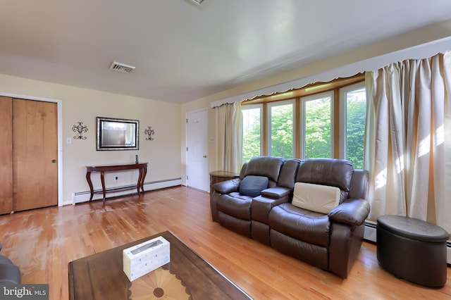 living area with visible vents, baseboard heating, and light wood-style floors