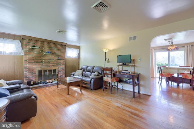 living area featuring visible vents, plenty of natural light, and wood finished floors